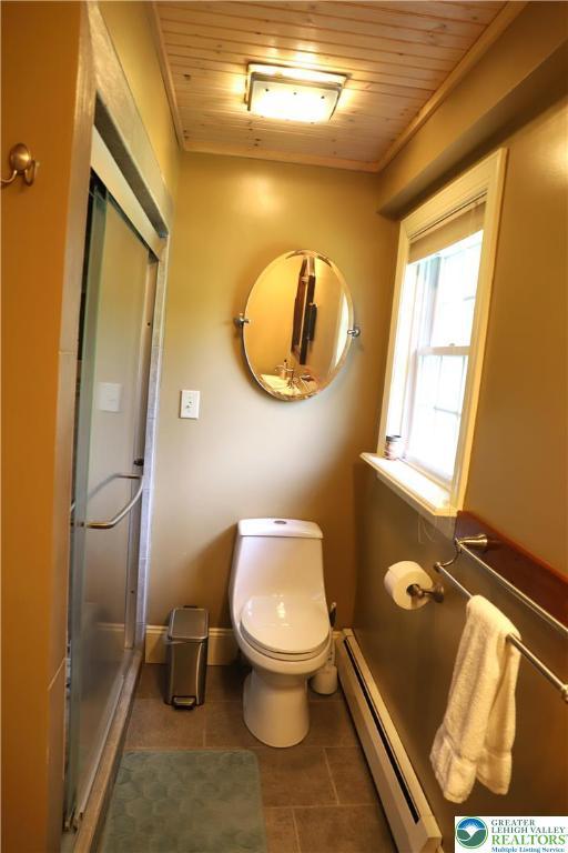 118 Burgoon Rd, Stroud Twp, PA 18301 - bathroom with baseboard heating, wood ceiling, tile patterned flooring, toilet, and a shower stall