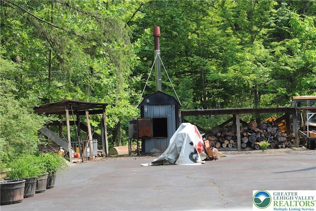 118 Burgoon Rd, Stroud Twp, PA 18301 - view of patio with a storage unit and a wooded view