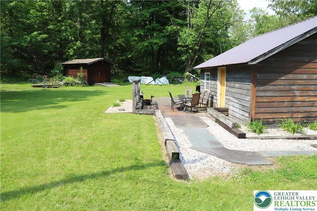 118 Burgoon Rd, Stroud Twp, PA 18301 - view of grassy yard with a storage unit and a patio