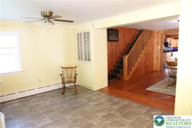 118 Burgoon Rd, Stroud Twp, PA 18301 - unfurnished room featuring baseboard heating, stairway, wooden walls, and a ceiling fan