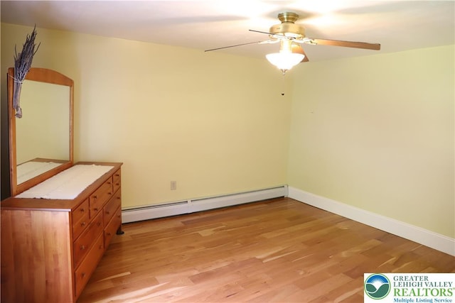 118 Burgoon Rd, Stroud Twp, PA 18301 - unfurnished bedroom featuring baseboard heating, light wood finished floors, baseboards, and a ceiling fan