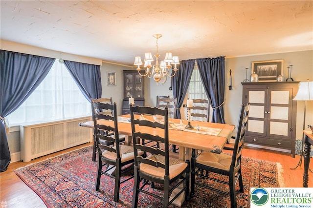 6650 Mountain Rd, Macungie Boro, PA 18062 - dining space with radiator heating unit, a chandelier, wood finished floors, and ornamental molding
