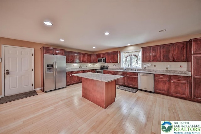 205 Osprey Way, Middle Smithfield Twp, PA 18302 - kitchen with appliances with stainless steel finishes, light wood-style floors, a kitchen island, recessed lighting, and light stone countertops