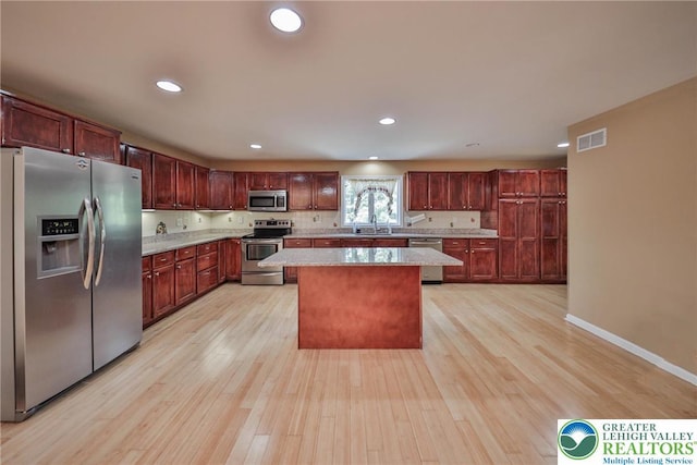 205 Osprey Way, Middle Smithfield Twp, PA 18302 - kitchen with appliances with stainless steel finishes, light wood-style floors, a kitchen island, dark brown cabinets, and recessed lighting