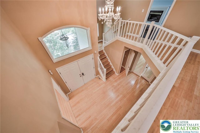 205 Osprey Way, Middle Smithfield Twp, PA 18302 - entryway featuring a high ceiling, wood finished floors, a chandelier, stairway, and a fireplace