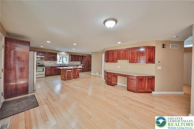 205 Osprey Way, Middle Smithfield Twp, PA 18302 - kitchen with stainless steel appliances, a breakfast bar area, light wood-style floors, recessed lighting, and a center island