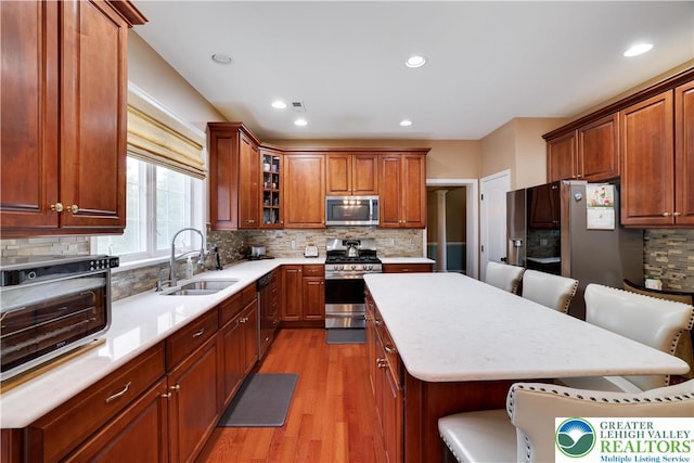 638 Stratton Dr, Middle Smithfield Twp, PA 18302 - kitchen with stainless steel appliances, light wood finished floors, tasteful backsplash, a kitchen breakfast bar, and a kitchen island