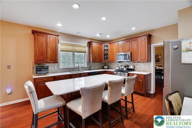 638 Stratton Dr, Middle Smithfield Twp, PA 18302 - kitchen with appliances with stainless steel finishes, a breakfast bar, wood finished floors, light countertops, and recessed lighting