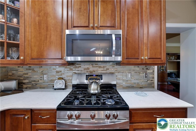 638 Stratton Dr, Middle Smithfield Twp, PA 18302 - kitchen featuring stainless steel appliances, backsplash, glass insert cabinets, and brown cabinets