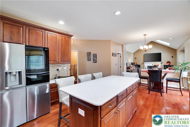 638 Stratton Dr, Middle Smithfield Twp, PA 18302 - kitchen with stainless steel fridge, a kitchen breakfast bar, light wood-type flooring, a kitchen island, and light countertops