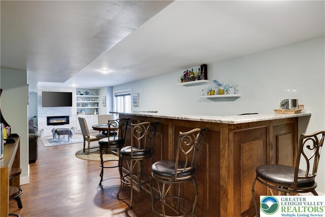 638 Stratton Dr, Middle Smithfield Twp, PA 18302 - indoor dry bar featuring a large fireplace, dark wood-type flooring, and built in shelves