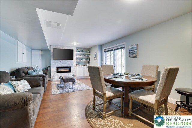 638 Stratton Dr, Middle Smithfield Twp, PA 18302 - dining room with a fireplace, wood finished floors, and built in shelves