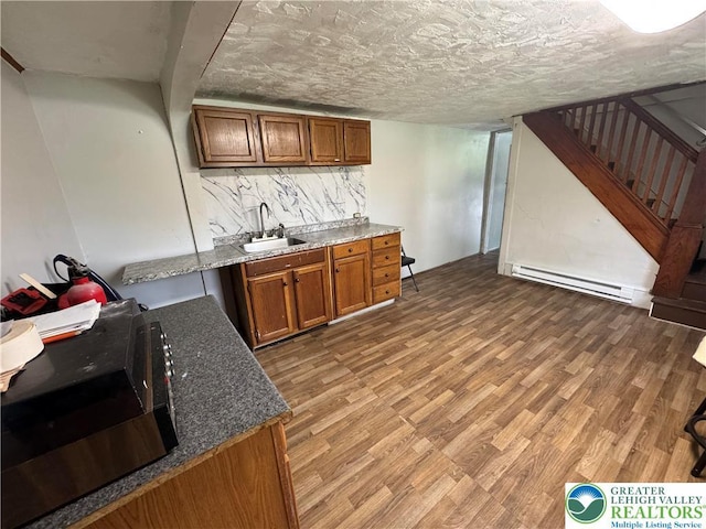 226 E Snyder Ave, Lansford Boro, PA 18232 - bar featuring baseboard heating, light wood finished floors, stairs, and backsplash