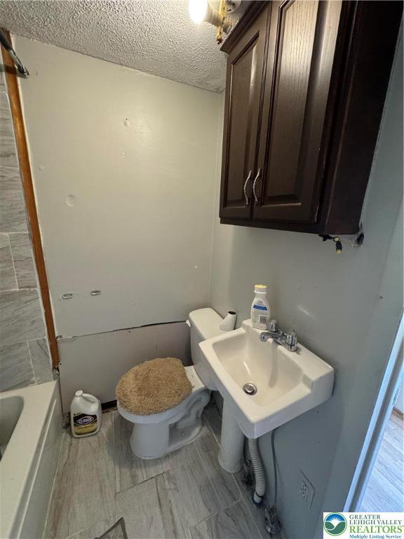 226 E Snyder Ave, Lansford Boro, PA 18232 - bathroom with a textured ceiling and a tub