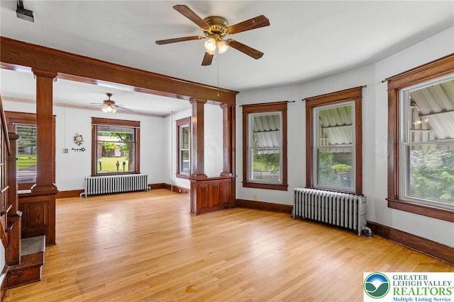 100 E Mahoning Dr, Mahoning Twp, PA 18235 - unfurnished living room featuring radiator heating unit, ceiling fan, light wood-type flooring, and decorative columns