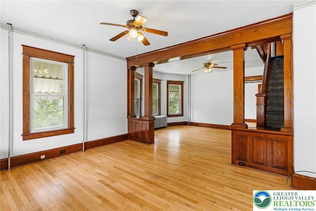 100 E Mahoning Dr, Mahoning Twp, PA 18235 - unfurnished living room featuring radiator, ceiling fan, light wood-type flooring, stairs, and ornate columns