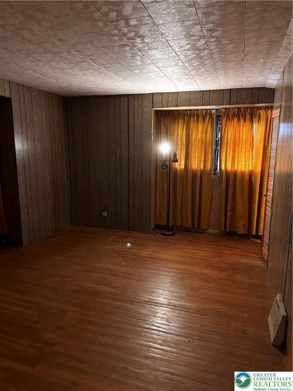 701 N Lacrosse St, Allentown City, PA 18109 - spare room with hardwood / wood-style flooring and wood walls