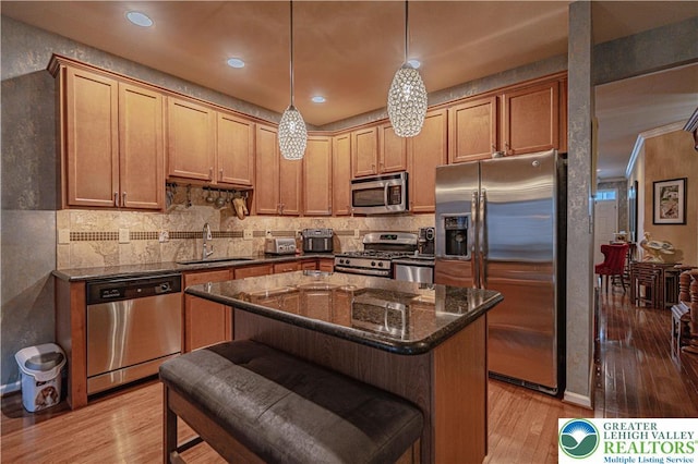 4549 Woodbrush Way, Upper Macungie Twp, PA 18104 - kitchen featuring appliances with stainless steel finishes, light wood-style floors, dark stone counters, decorative backsplash, and recessed lighting