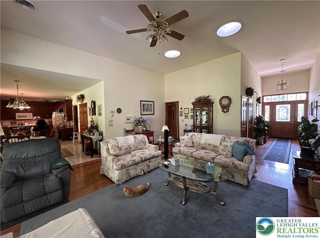 1437 Nectarine Rd, Lehigh Twp, PA 18038 - living room featuring wood finished floors, a ceiling fan, a chandelier, and a high ceiling