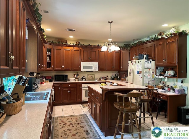 1437 Nectarine Rd, Lehigh Twp, PA 18038 - kitchen with white appliances, light countertops, a chandelier, a kitchen bar, and recessed lighting