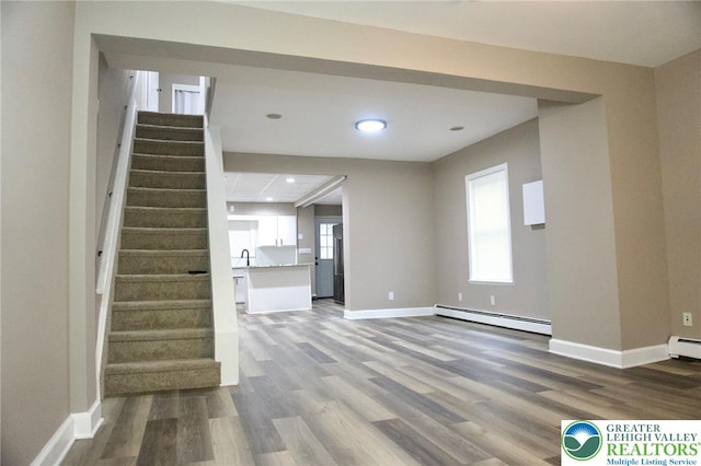 820 Ridge St, West Easton Borough, PA 18042 - unfurnished living room with a baseboard heating unit, wood finished floors, stairway, healthy amount of natural light, and recessed lighting