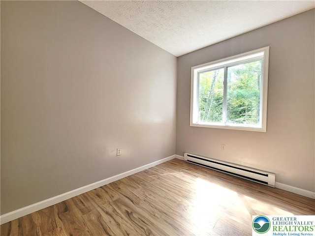6522 Runnymead, Coolbaugh Twp, PA 18466 - unfurnished room featuring baseboard heating, wood finished floors, a textured ceiling, and vaulted ceiling