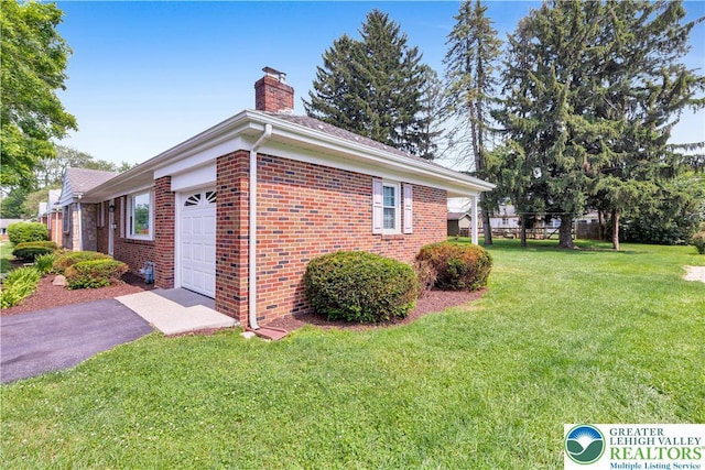 3032 W Woodlawn St, South Whitehall Twp, PA 18104 - view of property exterior featuring a chimney, brick siding, a lawn, an attached garage, and asphalt driveway