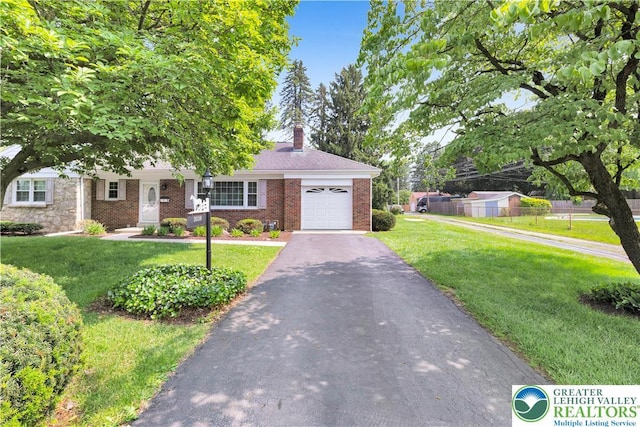 3032 W Woodlawn St, South Whitehall Twp, PA 18104 - view of front of property with a garage, asphalt driveway, a front yard, and brick siding