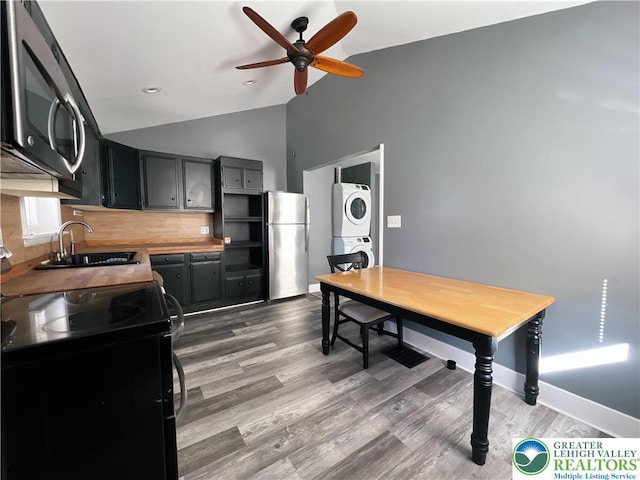 2236 2nd St, Easton, PA 18042 - kitchen featuring stainless steel appliances, stacked washing machine and dryer, a ceiling fan, backsplash, and wood finished floors