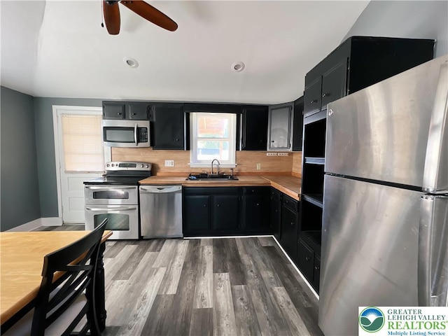 2236 2nd St, Easton, PA 18042 - kitchen with appliances with stainless steel finishes, dark cabinets, wood finished floors, and decorative backsplash
