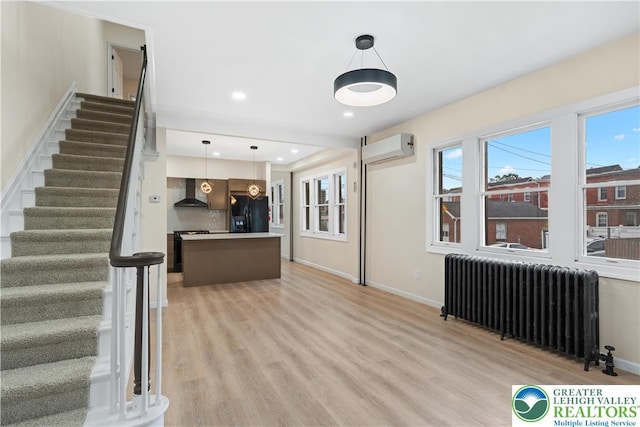 616 Highland Ave, Bethlehem City, PA 18018 - unfurnished living room featuring radiator, stairway, light wood finished floors, and a wall mounted air conditioner