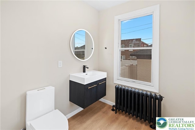616 Highland Ave, Bethlehem City, PA 18018 - half bath featuring radiator, vanity, and wood finished floors