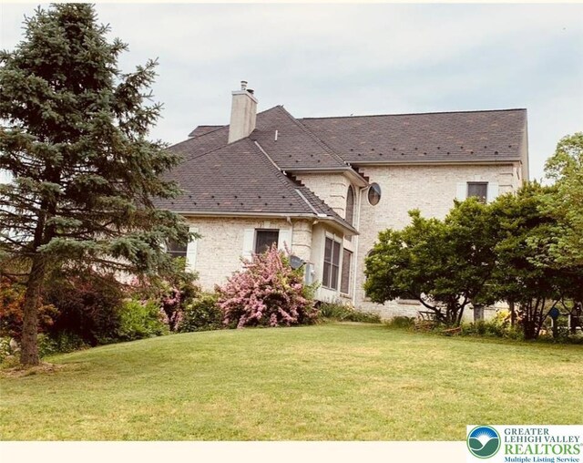 459 Mount Pleasant Rd, Washington Twp, PA 18013 - rear view of house with a chimney, a lawn, and stone siding