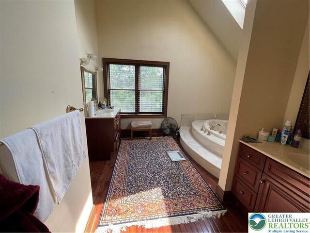 459 Mount Pleasant Rd, Washington Twp, PA 18013 - bathroom with two vanities, wood finished floors, a garden tub, and high vaulted ceiling