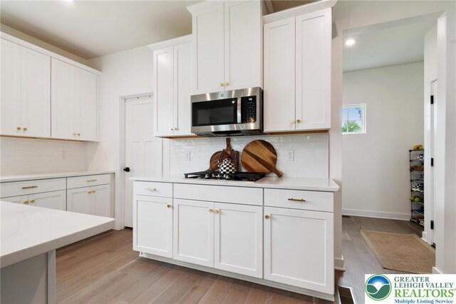 1615 Watson Loop, Upper Macungie Twp, PA 18051 - kitchen with stainless steel microwave, light countertops, tasteful backsplash, white cabinetry, and recessed lighting