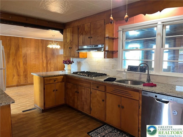 2115 Fireside Dr, Bethlehem City, PA 18018 - kitchen with stainless steel appliances, under cabinet range hood, wood finished floors, decorative backsplash, and wood walls