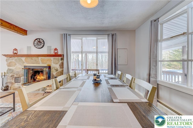 143 Cathleen Dr, Price Twp, PA 18302 - dining room with a textured ceiling, plenty of natural light, a baseboard radiator, and a stone fireplace