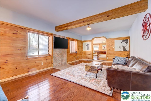143 Cathleen Dr, Price Twp, PA 18302 - living area featuring wood finished floors, wood walls, plenty of natural light, and beamed ceiling