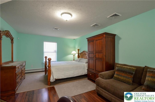 1214 Shadblow Rd, Tobyhanna Twp, PA 18346 - bedroom featuring baseboard heating, wood finished floors, and a textured ceiling