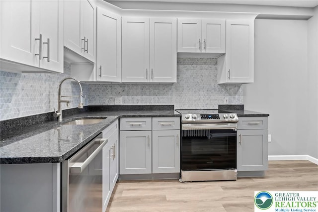 1478 E 5th St, Bethlehem City, PA 18015 - kitchen with stainless steel appliances, light wood-type flooring, dark stone countertops, and decorative backsplash