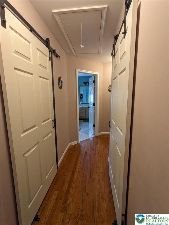 131 Winding Way, Washington Twp, PA 18013 - corridor with attic access, a barn door, and dark wood-type flooring