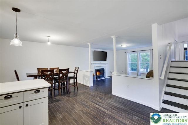 9436 Juniper Dr, Tobyhanna Twp, PA 18466 - dining room with a warm lit fireplace, stairway, and dark wood-style floors
