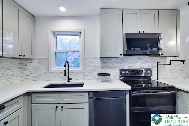9436 Juniper Dr, Tobyhanna Twp, PA 18466 - kitchen featuring stainless steel appliances, gray cabinetry, light countertops, and backsplash