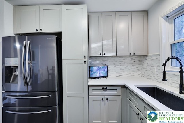 9436 Juniper Dr, Tobyhanna Twp, PA 18466 - kitchen featuring stainless steel refrigerator with ice dispenser, gray cabinetry, tasteful backsplash, and light countertops