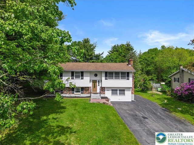 3315 Aspen Rd, Polk Twp, PA 18058 - bi-level home featuring asphalt driveway, a chimney, and a front yard