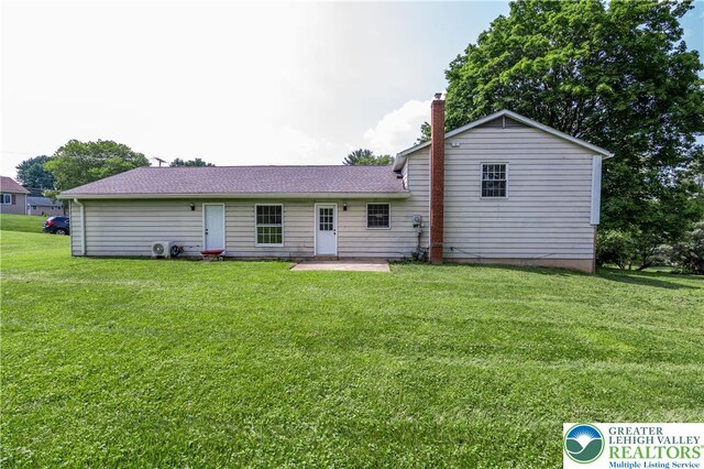 23 Devon Dr, Palmer Twp, PA 18045 - rear view of house with a yard, a chimney, a shingled roof, and a patio area