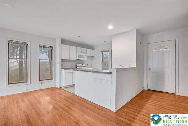 417 Hickory Dr, Jackson Twp, PA 18372 - kitchen featuring white appliances, white cabinetry, a peninsula, light wood-type flooring, and dark countertops