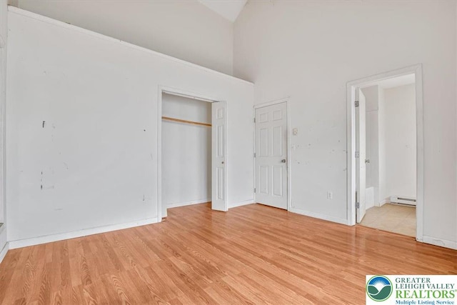 417 Hickory Dr, Jackson Twp, PA 18372 - unfurnished bedroom with baseboard heating, light wood-style flooring, high vaulted ceiling, and ensuite bathroom