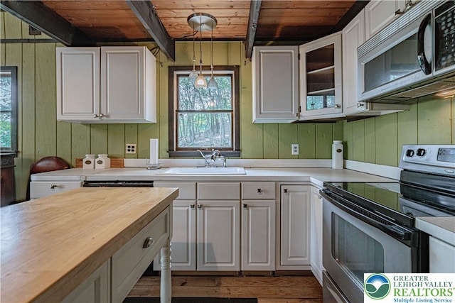 115 Lookout Ct, Middle Smithfield Twp, PA 18302 - kitchen with appliances with stainless steel finishes, a wooden ceiling with exposed beams, plenty of natural light, white cabinetry, and wooden walls