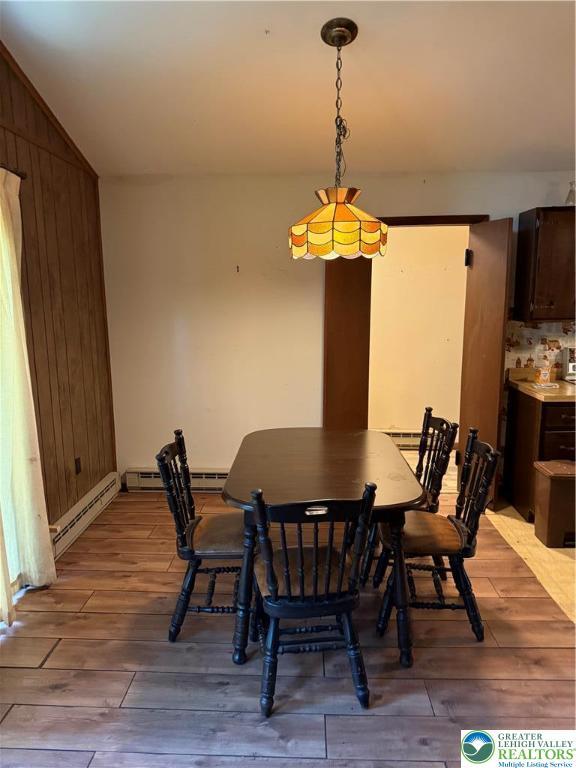 9817 Deerwood Dr, Coolbaugh Twp, PA 18466 - dining area with hardwood / wood-style floors, wood walls, vaulted ceiling, and a baseboard heating unit